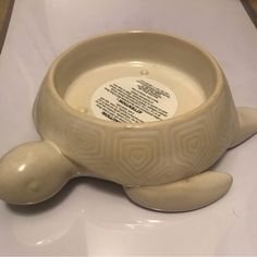 a ceramic bowl with a turtle design on the bottom and inside, sitting on a white surface