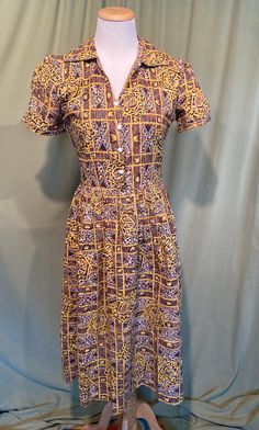 This is a cute vintage dress from the late 40s or early 50s.  No labels or tags it is home sewn. The bust measures 34", waist 26", hip 52", see measurements below.  Made of a cotton fabric in a brown, yellow, black & white busy tribal or tropical style print pattern. It has short sleeves with small, folded cuffs & ruched center panels.  It has a small V neck & pointed, split collar. No pockets.  Buttons to the waist seam down the front with 4 swirled, dome white plastic buttons. Closes on the left side with a metal zipper. It is a fit & flair shape with a gathered full skirt.  The dress is in very good condition. No repairs or damage, no soil or stains.  Sweet! Measurements were taken with the garment lying flat. If you have never worn vintage before, please measure yourself or a similar g Fitted Retro Vintage Dress With Button Closure, Retro Cotton Vintage Dress With Vintage Pattern, Vintage Cotton Dress With Buttons, Cotton Vintage Dress With Buttons, Retro Vintage Dress With Buttons For Daywear, Retro Vintage Dress With Button Closure, Retro Vintage Dress With Buttons, Vintage Brown Short Sleeve Dress, Brown Vintage Short Sleeve Dress