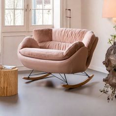 a living room with a rocking chair and table next to a tree stump in the corner