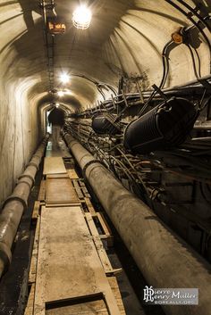 the inside of a tunnel with pipes and lights