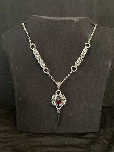 This lightweight bracelet is handmade from Aluminum rings using a byzantine weave to make the pendant and chains. From clasp to O-ring this necklace is 19 inches long. The Red Byzantine Pendant Necklace is perfect for men, women, and anyone in-between. This necklace is shipped in a fleece pouch. Gothic Chainmail Jewelry Gift, Gothic Stainless Steel Chainmail Jewelry, Byzantine Chain Jewelry For Gifts, Byzantine Chain Jewelry As Gift, Byzantine Style Chain Jewelry For Gifts, Byzantine Chain Jewelry Gift, Stainless Steel Jewelry Making Jump Rings, Byzantine Necklace, Unique Shirt