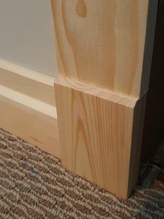 a piece of wood sitting on top of a carpeted floor next to a wall