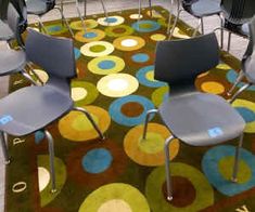 several chairs are arranged on a rug in the middle of a room with colorful circles