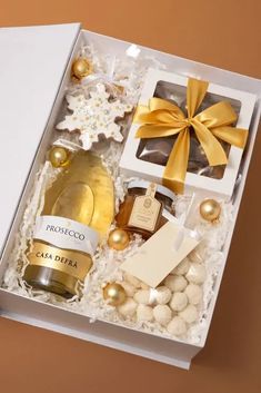 an open gift box filled with champagne, cookies and candies