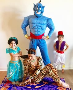 three children are dressed up in costumes and posing for a photo with an evil man