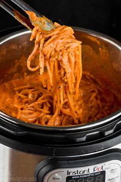 a spoon full of spaghetti being lifted from an instant pot