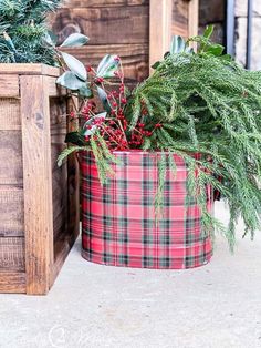 two potted plants sitting next to each other in front of a wooden box filled with greenery