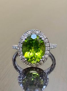 DeKara Designs Collection Our latest design! An elegant and lustrous Peridot surrounded by beautiful diamonds in a halo setting. Metal- 14K Whitee Gold, .583. Stones- Center Features a Oval Fiery Peridot, 11 MM Long, 9 MM Wide, 44 Round Diamonds, H Color VS2-SI1 Clarity, 0.35-0.40 Carats. Latest of my creations. A beautiful Peridot Halo Diamond Ring Made in 14K White Gold. The peridot is professionally prong set in between 4 double prongs. There are 10 pave set round diamonds on each side of the Wedding Jewelry With Brilliant Cut Peridot, Peridot Rings With Brilliant Cut In Fine Jewelry Style, Fine Jewelry Peridot Rings With Brilliant Cut, Green Peridot Rings With Brilliant Cut, Oval Peridot Diamond Ring For Formal Occasions, Formal Peridot Diamond Ring With Center Stone, Formal Oval Peridot Diamond Ring, Formal Lime Green Rings With Center Stone, Wedding Jewelry With Peridot In Halo Setting