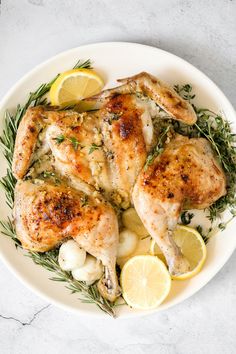 a white plate topped with chicken and lemons