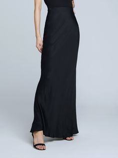 A stunning, understated maxi skirt in pure black. Bias-cut, silk-like fabric falls in a subtle, lustrous cling over the figure, enhancing and elongating the silhouette. Smooth elastic waist with no closures. Sleek Black Satin Finish Maxi Dress, Sleek Full-length Bias-cut Maxi Dress, Sleek Solid Color Maxi Dress For Formal Occasions, Elegant Black Bottoms With Satin Finish, Elegant Maxi Skirt For Night Out, Elegant Long Skirt For Evening, Sleek Silk Evening Bottoms, Sleek Silk Bottoms For Evening, Elegant Long Evening Skirt