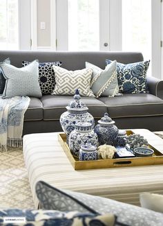 a living room filled with lots of blue and white decor on top of a couch