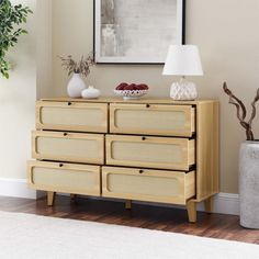 a wooden dresser sitting next to a plant in a living room