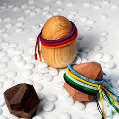 several bracelets and a wooden object on a white surface with circles in the background