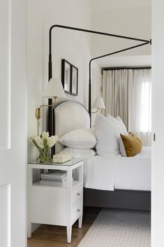 a bedroom with a bed, nightstand and mirror