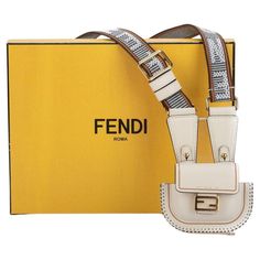 Fendi micro necklace bag in white. Attached to it is a fabric strap (18") with Fendi written on it. The strap has a light grey-tone. The bag closes with the typical F logo clasp on the front. The piece is new and comes with a box and dustcover. F Logo, Accessory Pouch, Grey Tones, The Bag, Small Accessories, West Hollywood, Fashion Handbags, Purse Wallet, A Box