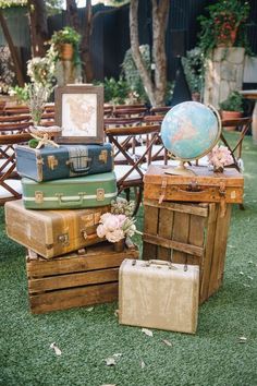 several suitcases stacked on top of each other in front of a table with chairs