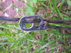 a close up of a rope with a metal buckle on it and grass in the background