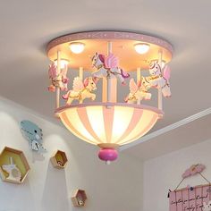 a child's bedroom with pink and white decor on the ceiling, bedding and wall hangings