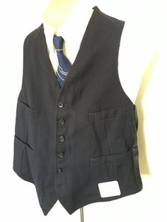 I was fortunate to recently pick up a nice large lot of vintage deadstock men's vests from the stock room of a men's clothing store liquidation. These vests had been packed up forgotten and stored for decades before being brought out again! This vest is a lovely dark navy blue (almost or possibly black?) with a very subtle broken line pinstripe of aqua blue and red. It has six buttons and four pockets. Condition: Deadstock, new old stock, dry clean recommended before use. No noted flaws. Era: 19 Men's Vests, Mens Clothing Store, Mens Vests, Dark Navy Blue, Blue Wool, Mens Vest, Mad Men, Vest Dress, Dark Navy