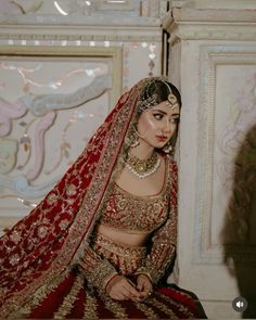 a woman in a red and gold bridal outfit