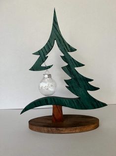 a wooden christmas tree with a glass ornament on top