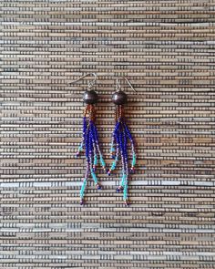 These long fringe beaded dangle earrings are certain to bring you admiring gazes!  Each earring has five strands of woodsy brown, cobalt blue, variegated iridescent  purple, sky blue, and copper color glass seed beads flowing from a round wooden bead.  These long, colorful, boldly addictive beaded earrings are unique, very lightweight and comfortable.  The strands are made with durable nylon beading thread and glass seed beads. The length of these earrings is 3.75 inches (from the top of the ear wire to the bottom of the beaded strands).  They have stainless steel hook style ear wires.  I love to use these particular ear wires because they hold the earring up, very close to your ear so there is no "wasted space".   beaded bracelets: https://www.etsy.com/shop/RanchoArt?section_id=26148298 T Southwestern Fringe Earrings With Round Beads, Southwestern Fringe Dangle Earrings, Southwestern Beaded Fringe Dangle Earrings, Southwestern Style Beaded Fringe Dangle Earrings, Bohemian Beaded Fringe Dangle Earrings, Bohemian Beaded Dangle Earrings With Fringe, Southwestern Fringe Jewelry With Round Beads, Bohemian Chandelier Earrings With Fringe And Round Beads, Bohemian Chandelier Earrings With Fringe