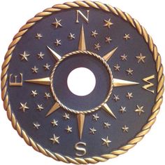 a black and gold compass with stars in the center on a pink background for children's rooms