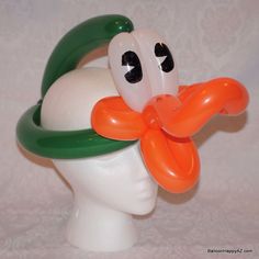 a white head with an orange and green balloon attached to it