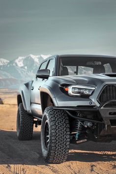 a black truck driving down a dirt road