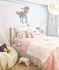 a bedroom with pink and white bedding on the walls, an animal decal above the bed