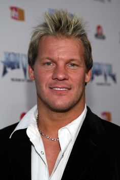 a man with blonde hair wearing a black suit and white shirt