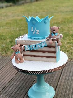 there is a cake with two teddy bears on it and the first one has a blue crown