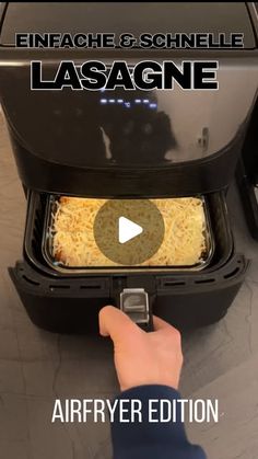 an air fryer with the words lasagne in front of it and someone's hand reaching for food