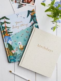 two personalized notebooks sitting next to each other on top of a white table