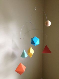 an origami mobile hanging from the ceiling in a child's playroom