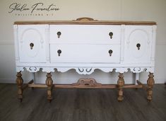 an old dresser is painted white and has wood handles on the top, along with wooden legs