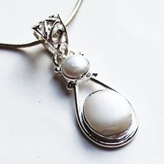 "This hand-crafted semi-precious stone pendant which features a gorgeous white Pearls set in solid 925 sterling silver. Stone: Pearl   Colour: White  Metal: 100% Solid Sterling Silver Pendant Size: 3 x 1.2 (Excluding Bail) Chain: 18\" solid sterling silver Materials: Each one-of-a-kind piece of jewellery is lovingly hand crafted using top quality semi-precious natural gemstones and solid 925 sterling silver, so that you can treasure your piece for a lifetime.  Gift Boxes: each unique piece is al Sterling Silver White Gold Jewelry With Pearl Pendant, White Gemstone Necklace With Mother Of Pearl, White Gold Sterling Silver Pearl Pendant Jewelry, Sterling Silver Pearl Pendant Fine Jewelry, Sterling Silver Fine Jewelry With Pearl Pendant, White Gemstone Pendant Jewelry, White Oval Pendant Necklace With Polished Finish, White Oval Pendant With Polished Finish, Spiritual White Jewelry For Gifts