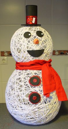 a snowman made out of yarn with a red scarf around his neck