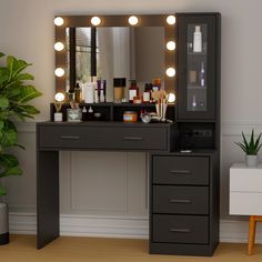 a vanity with lights on it in front of a mirror and potted plant next to it