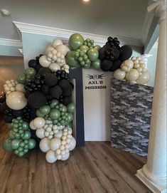 an arch made out of balloons in the middle of a room with wood flooring