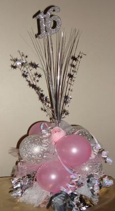 a birthday centerpiece with balloons and streamers