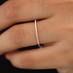 a woman's hand with a diamond ring on top of her left hand,