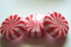 three red and white candy canes sitting on top of a table next to each other