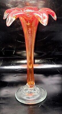 an orange glass vase sitting on top of a table