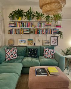 a living room filled with lots of furniture and bookshelves on the wall above