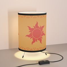 a lamp that is on top of a table next to a charger and plugged in