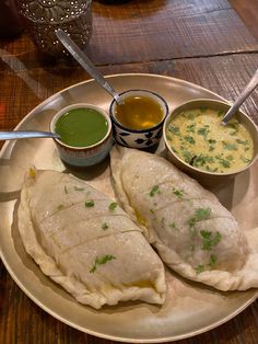 two fish fillets on a plate with dipping sauces