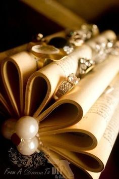 an open book with rings and pearls on it