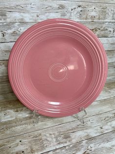 a pink plate sitting on top of a wooden table