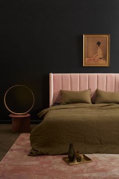 a bedroom with black walls and a pink bed in the middle, along with a painting on the wall